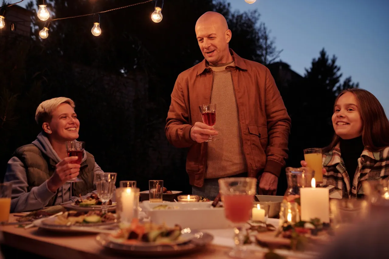 A host raising a glass at a dinner party