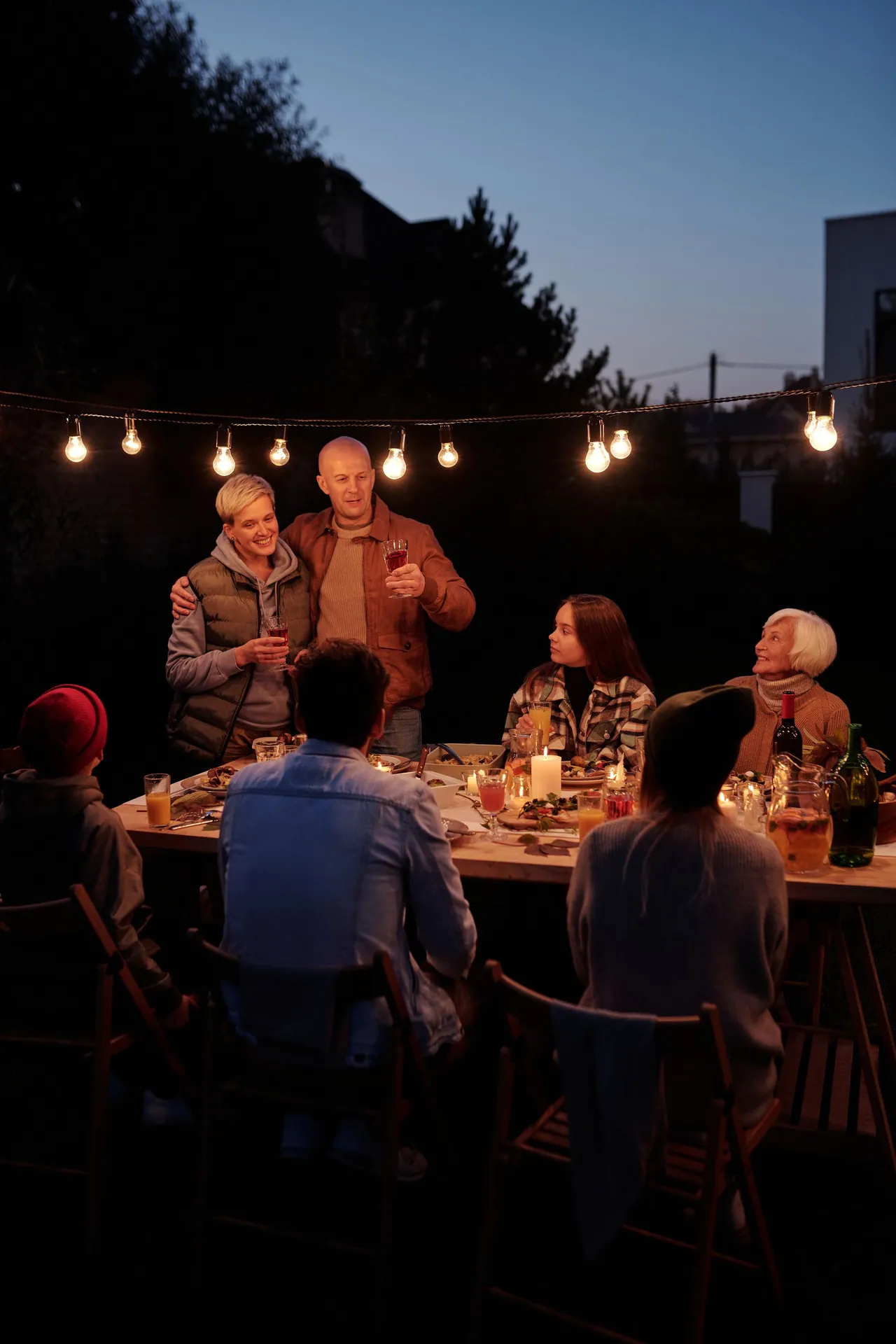 A long table set for a large dinner party at night